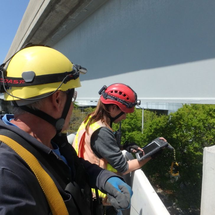 Two inspectors from FIT Engineering preparing to inspect a bridge with special tools.